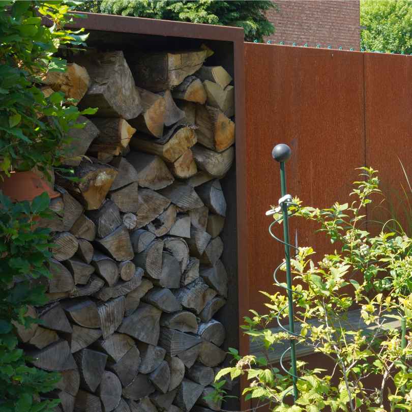 Cortenstahl Holzlager in eine Sichtschutzwand eingebaut