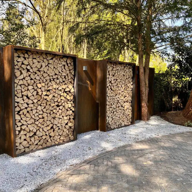 Zwei Cortenstahl Holzlager auf Kies an einer Cortenstahl Sichtschutzwand