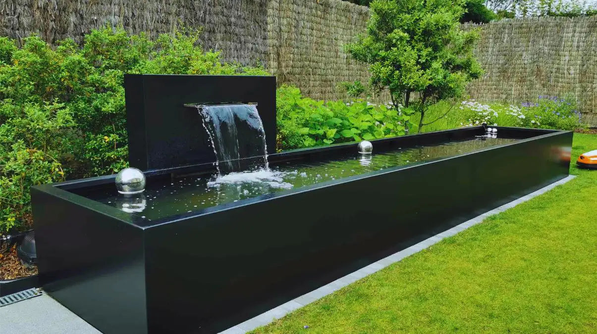 Aluminium Wasserwand mit einem Aluminium Wasserbecken in einem Garten