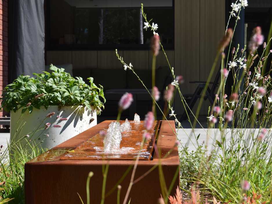 Wassertisch aus Cortenstahl in einem Garten