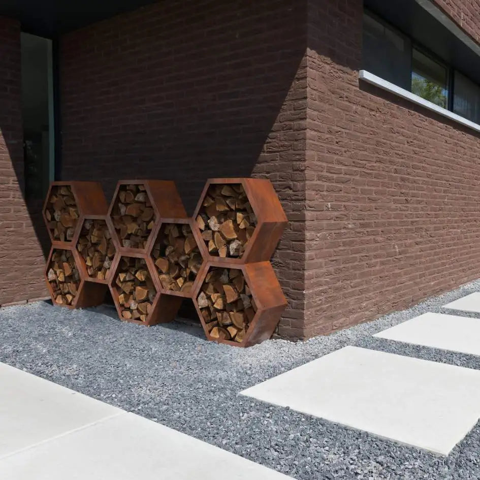 Modulares Holzlager aus Cortenstahl in Wabenform an einer Backsteinhauswand