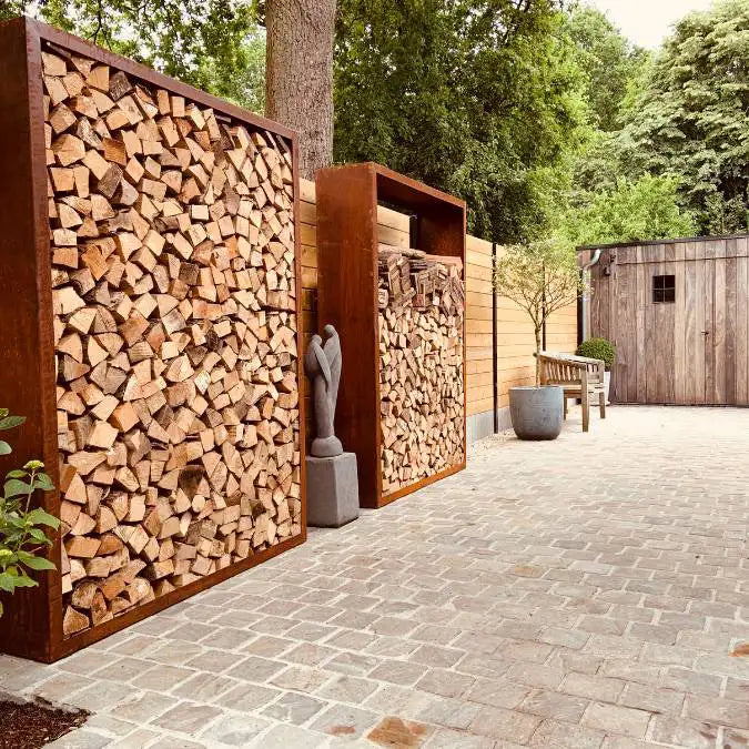 Zwei Cortenstahl Holzlager in einem Hinterhof vor einem Holzzaun